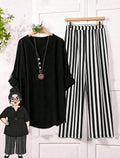 Conjunto casual de dos piezas incluye una blusa de talla grande de unicolor con cuello en V manga larga, y pantalones de pierna ancha estampados a rayas en blanco y negro.